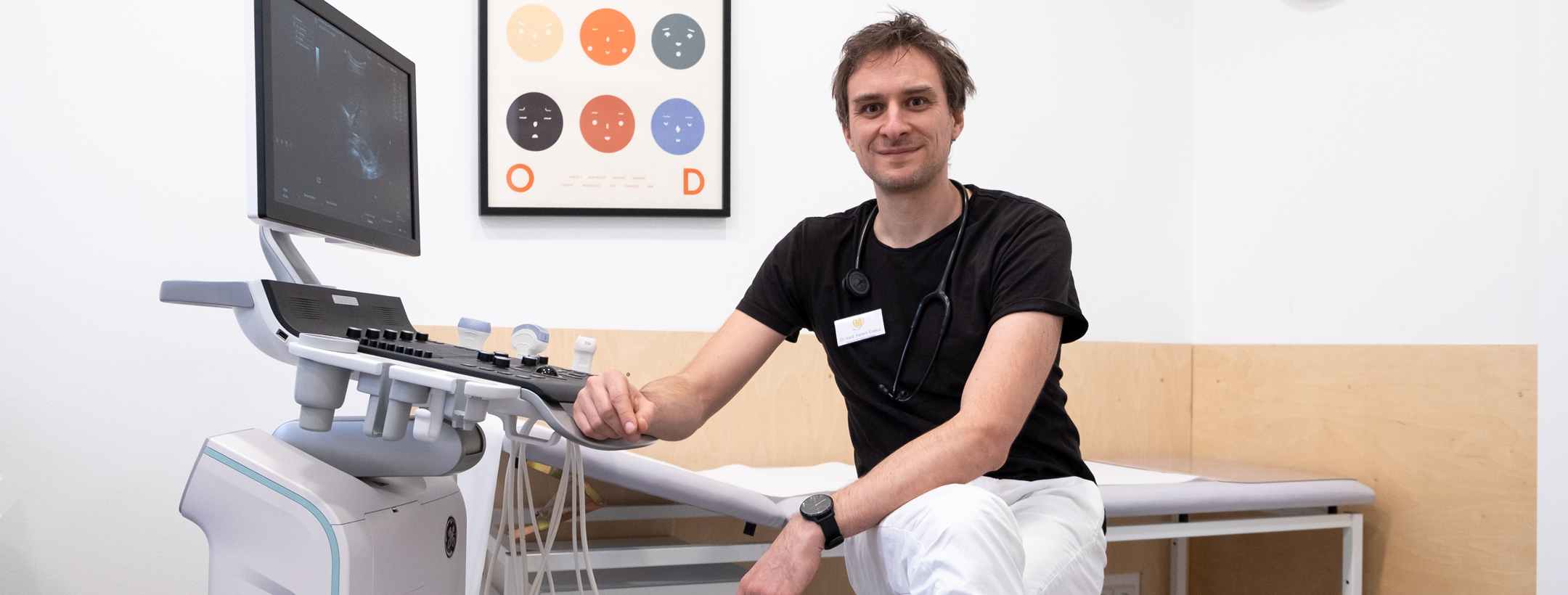 Arzt sitzt am Ultraschallgerät.