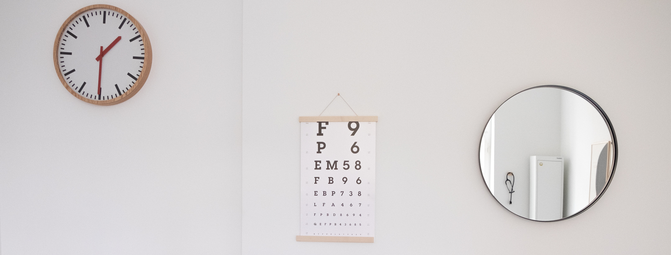 Uhr, Sehtest mit Buchstaben und Ziffern, Spiegel an der Wand